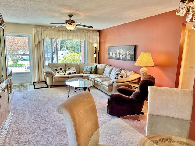 carpeted living room featuring ceiling fan and a textured ceiling