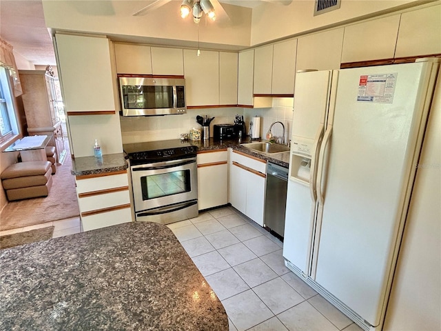 kitchen featuring sink, stainless steel appliances, cream cabinets, light tile patterned flooring, and decorative backsplash