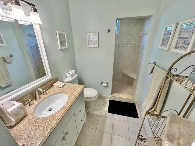 bathroom featuring tiled shower, vanity, toilet, and tile patterned floors