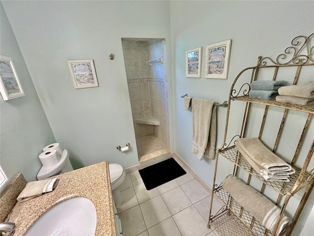 bathroom with tiled shower, sink, tile patterned floors, and toilet