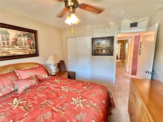 carpeted bedroom with ceiling fan and a closet