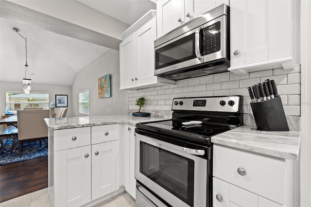 kitchen featuring kitchen peninsula, white cabinets, stainless steel appliances, and lofted ceiling