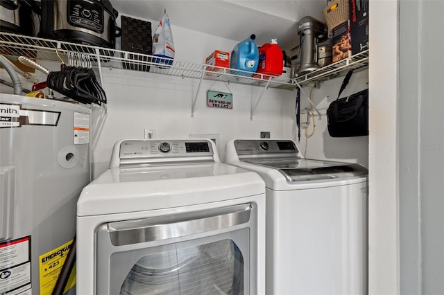 clothes washing area featuring separate washer and dryer and electric water heater