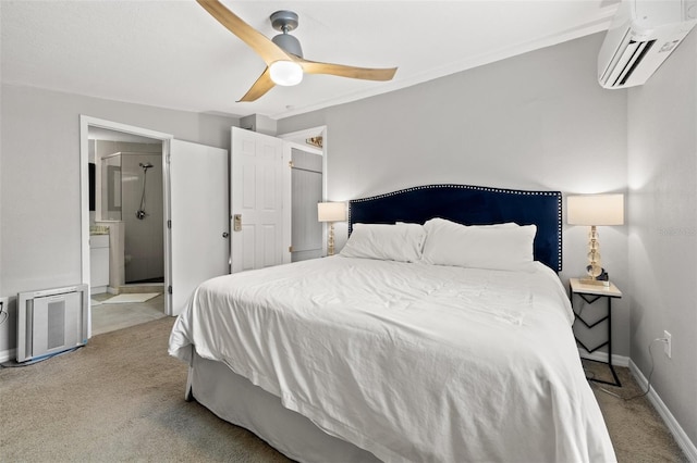 bedroom featuring ceiling fan, ensuite bathroom, an AC wall unit, and light carpet