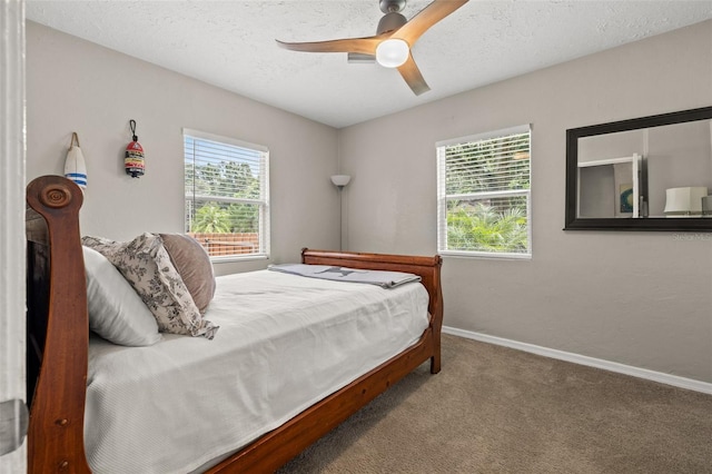 carpeted bedroom with multiple windows, a textured ceiling, and ceiling fan