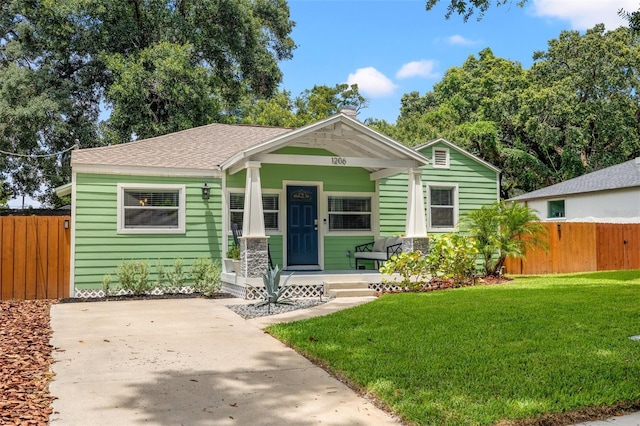 bungalow-style house featuring covered porch and a front yard