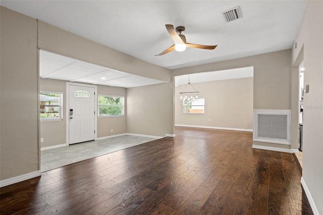 foyer entrance with hardwood / wood-style flooring and ceiling fan with notable chandelier