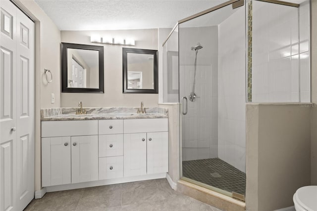 bathroom with a textured ceiling, tile patterned floors, vanity, walk in shower, and vaulted ceiling