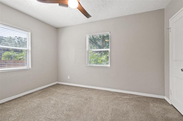 unfurnished room with ceiling fan, carpet flooring, and a textured ceiling