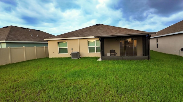 rear view of house with a yard and central air condition unit