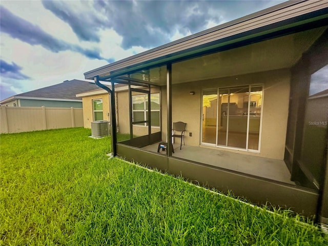 back of house with cooling unit and a lawn