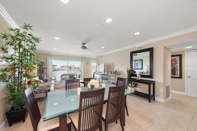 tiled dining area with crown molding and ceiling fan