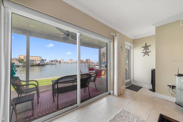 entryway featuring a water view, ceiling fan, ornamental molding, and light tile patterned flooring