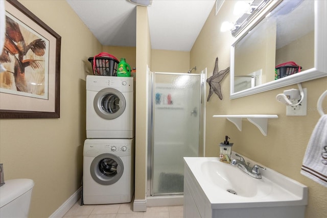 laundry area featuring light tile patterned flooring, stacked washer and clothes dryer, and sink