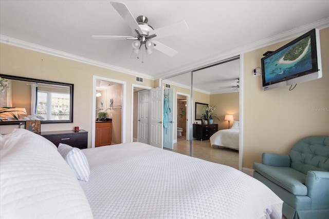 bedroom with ornamental molding, ensuite bathroom, ceiling fan, and a closet