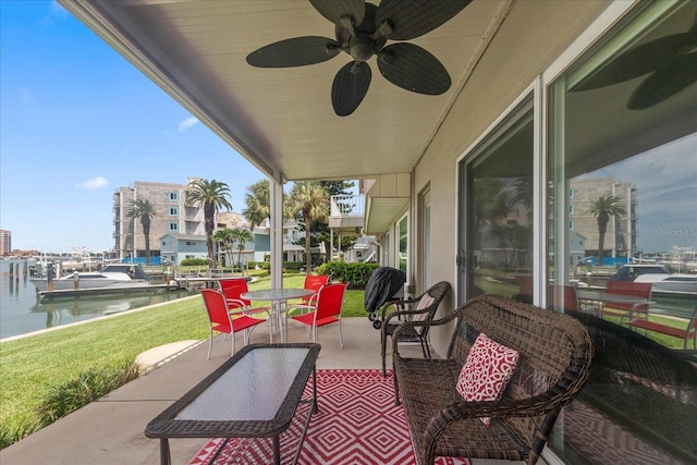 view of patio / terrace with ceiling fan and a water view