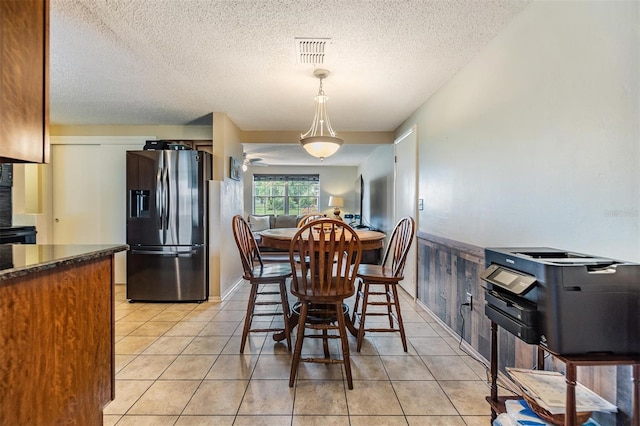 tiled dining room with a textured ceiling