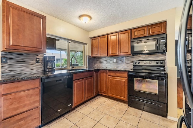 kitchen featuring sink, black appliances, light tile patterned floors, and backsplash