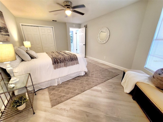 bedroom featuring light hardwood / wood-style floors, ceiling fan, and a closet