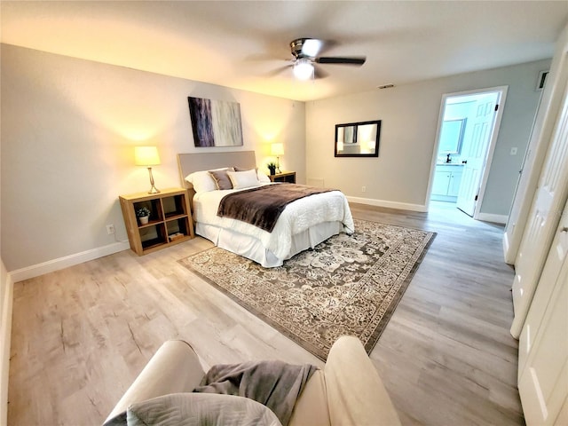 bedroom with ceiling fan, ensuite bath, and light wood-type flooring