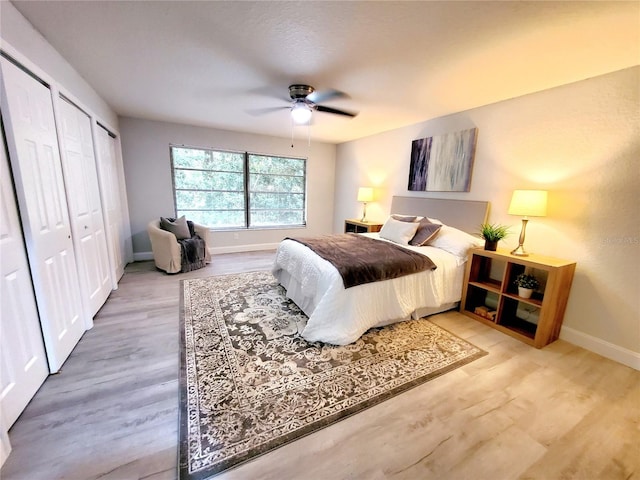 bedroom with light wood-type flooring, ceiling fan, and a closet