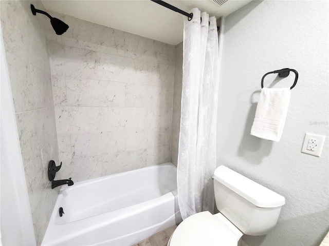 bathroom with hardwood / wood-style flooring, shower / bath combo, and toilet