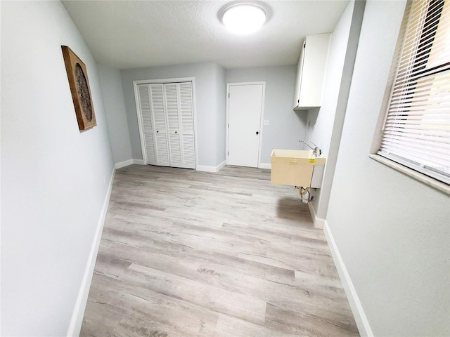 washroom featuring sink, a textured ceiling, and light hardwood / wood-style floors