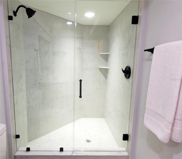 full bathroom with a shower stall and toilet