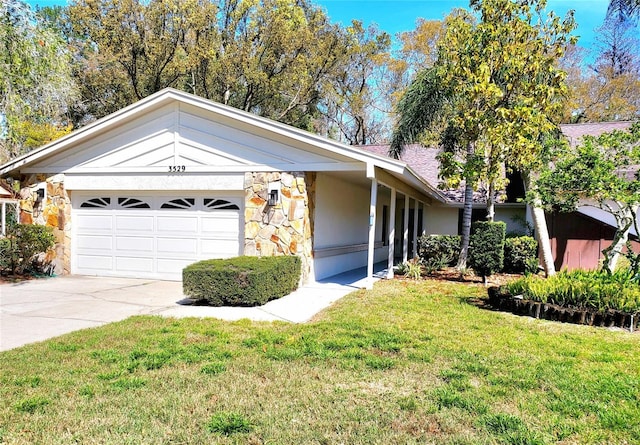 ranch-style home with an attached garage, stone siding, a front lawn, and concrete driveway