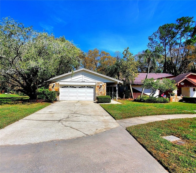 single story home with an attached garage, concrete driveway, stone siding, and a front yard