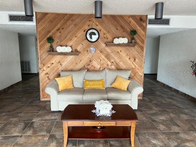 tiled living room with a textured ceiling and wooden walls