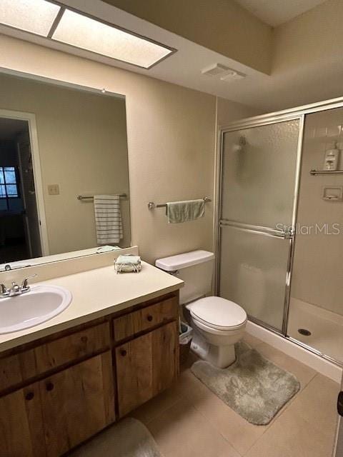 bathroom featuring vanity, an enclosed shower, tile patterned floors, and toilet