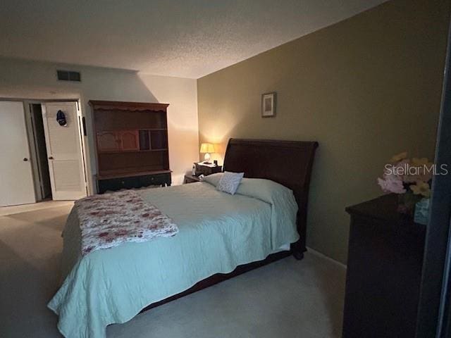 bedroom featuring carpet and a textured ceiling