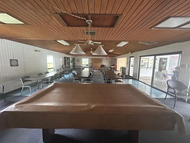 game room featuring wood ceiling and wood walls