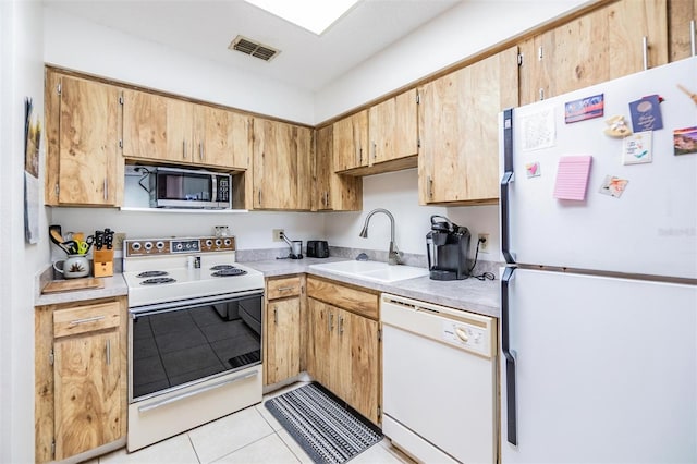 kitchen with sink, light tile patterned floors, and white appliances