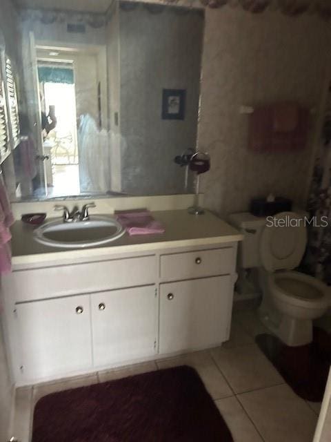 bathroom featuring vanity, tile patterned floors, and toilet