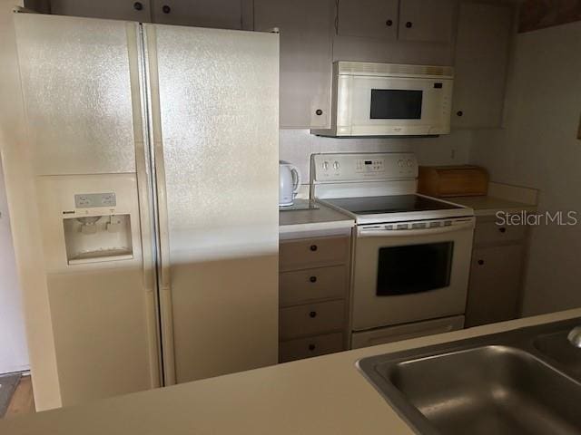 kitchen featuring white appliances and sink