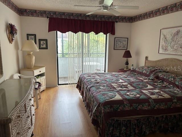 bedroom with ceiling fan, light wood-type flooring, a textured ceiling, and access to outside