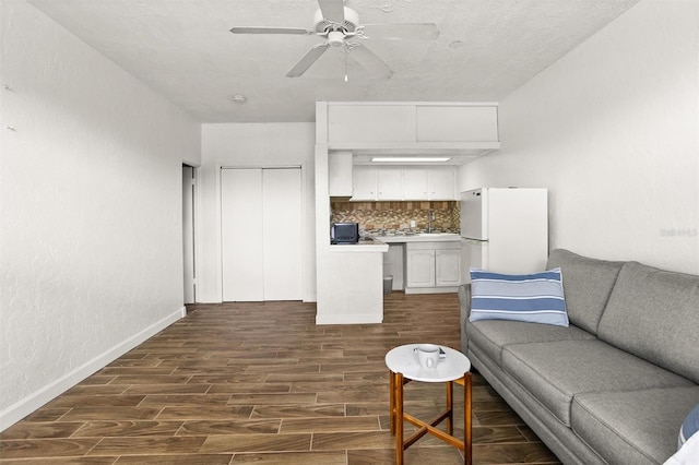 living room featuring ceiling fan and dark hardwood / wood-style floors