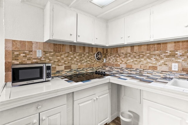 kitchen featuring white cabinets and tasteful backsplash