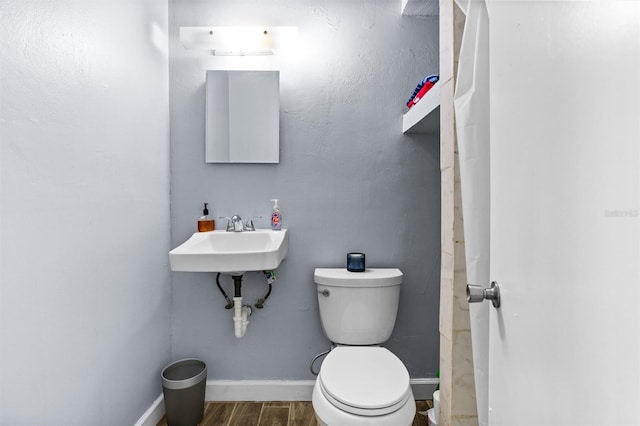 bathroom featuring sink, wood-type flooring, and toilet