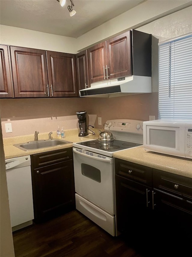 kitchen with white appliances, dark brown cabinetry, dark hardwood / wood-style floors, and sink