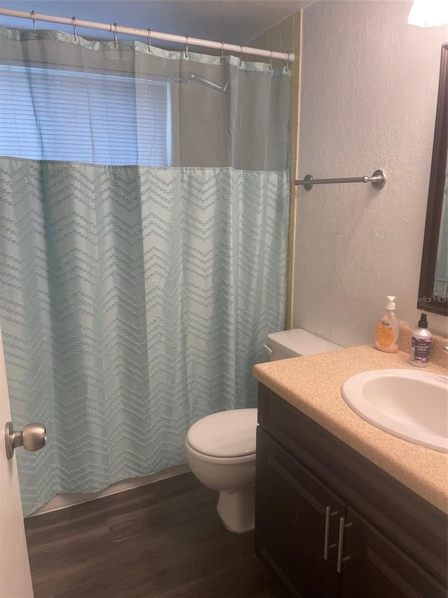 bathroom featuring vanity, wood-type flooring, and toilet