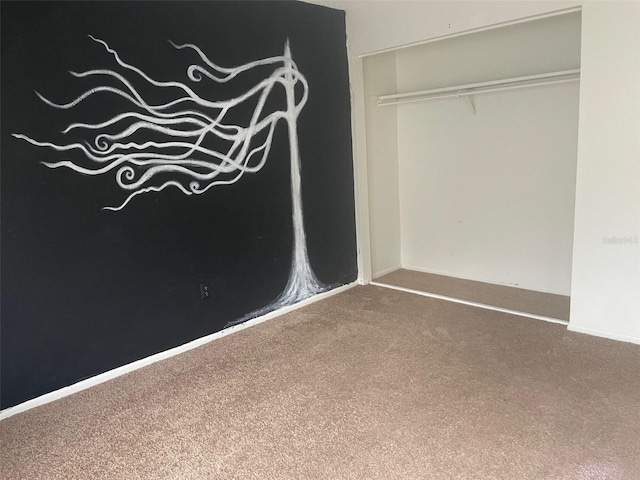 unfurnished bedroom featuring carpet floors and a closet