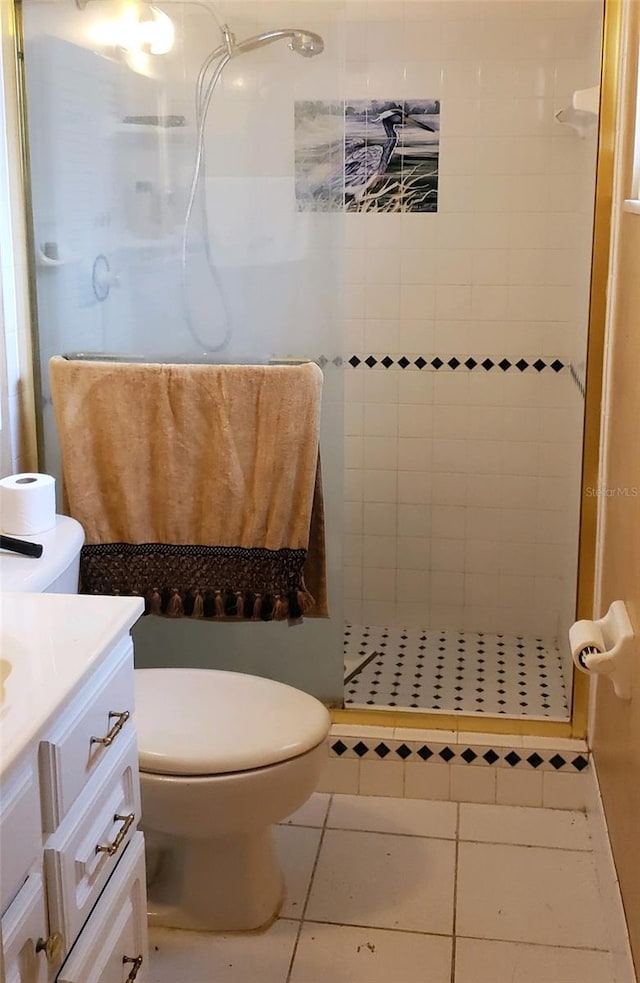 bathroom featuring tile patterned floors, vanity, tiled shower, and toilet