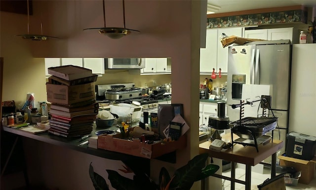 interior space with white cabinets, tile patterned floors, and appliances with stainless steel finishes