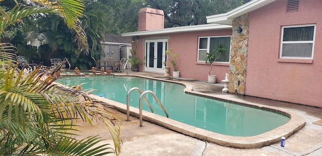 view of pool with a patio and french doors