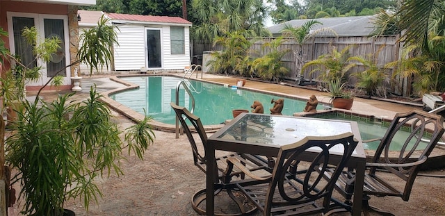 view of swimming pool with a patio and an outbuilding