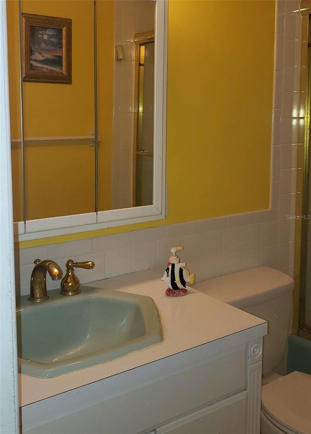 bathroom with backsplash, tile walls, toilet, and vanity