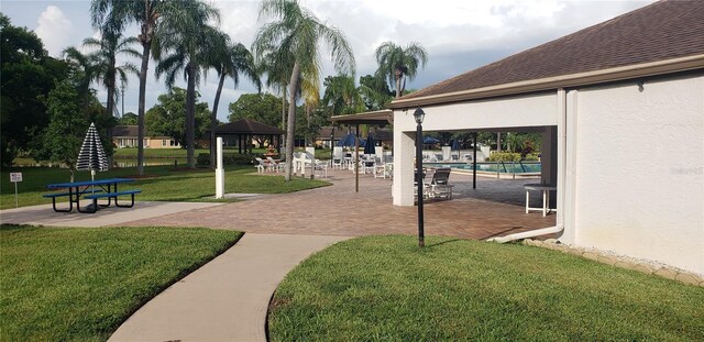 surrounding community with a gazebo, a lawn, and a swimming pool